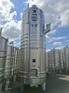 Grande cuve de vinification en inox avec ceintures de thermorégulation et accessoires, prête pour la livraison.