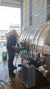 Opérateur Métalinox effectuant des opérations de nettoyage et de finition sur la surface extérieure d'une cuve inox