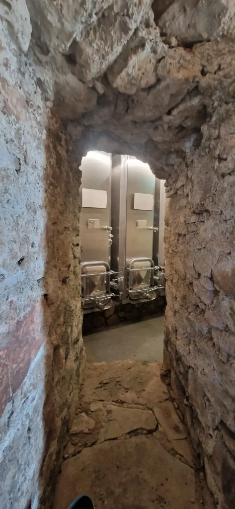 accès étroit et arche en pierre de la cave voutée du domaine viticole