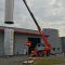 Personnel Métalinox en nacelle guidant le positionnement d'une cuve viticole.
